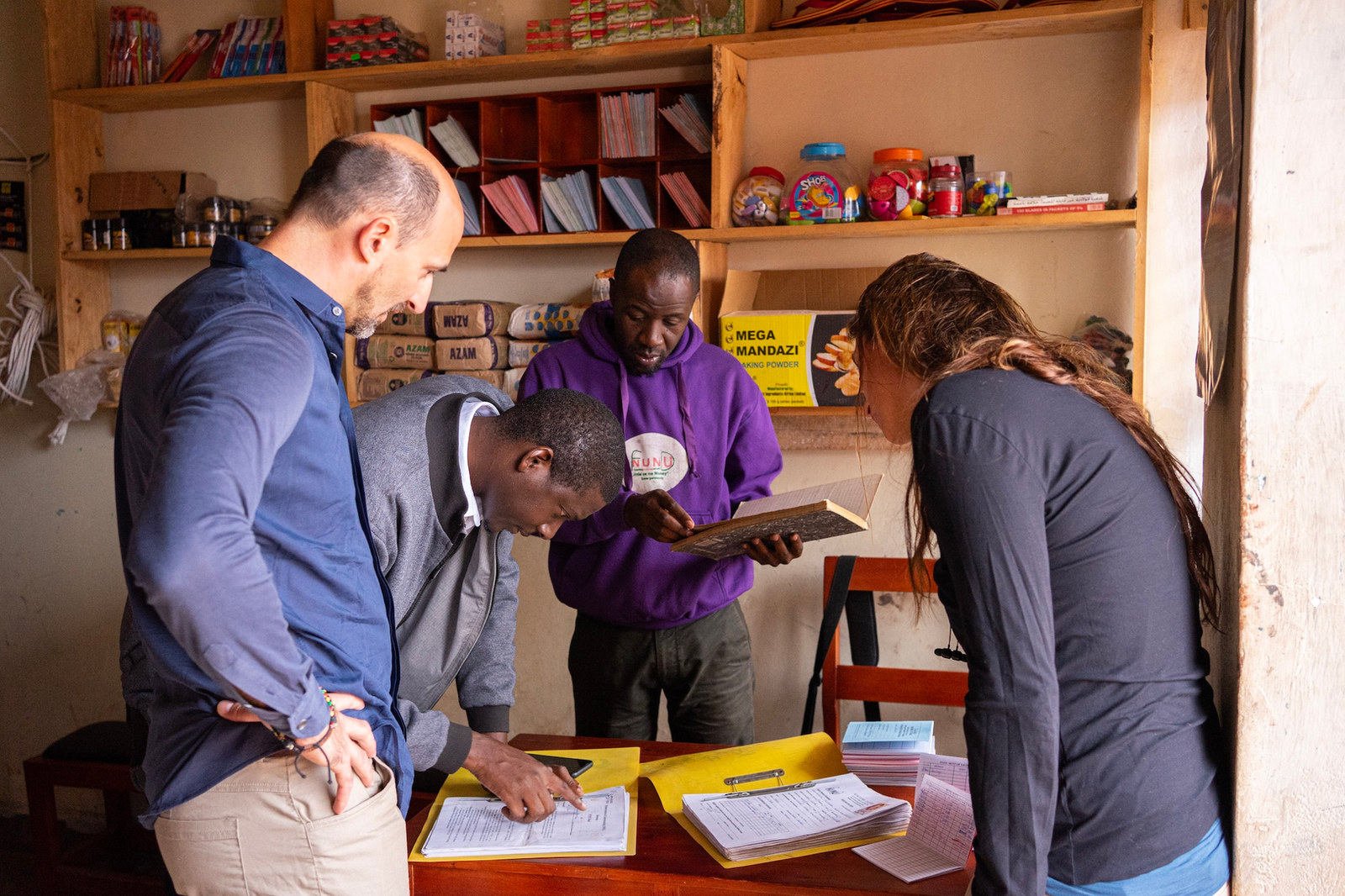 RAIN team members reviewing documents with a shop owner